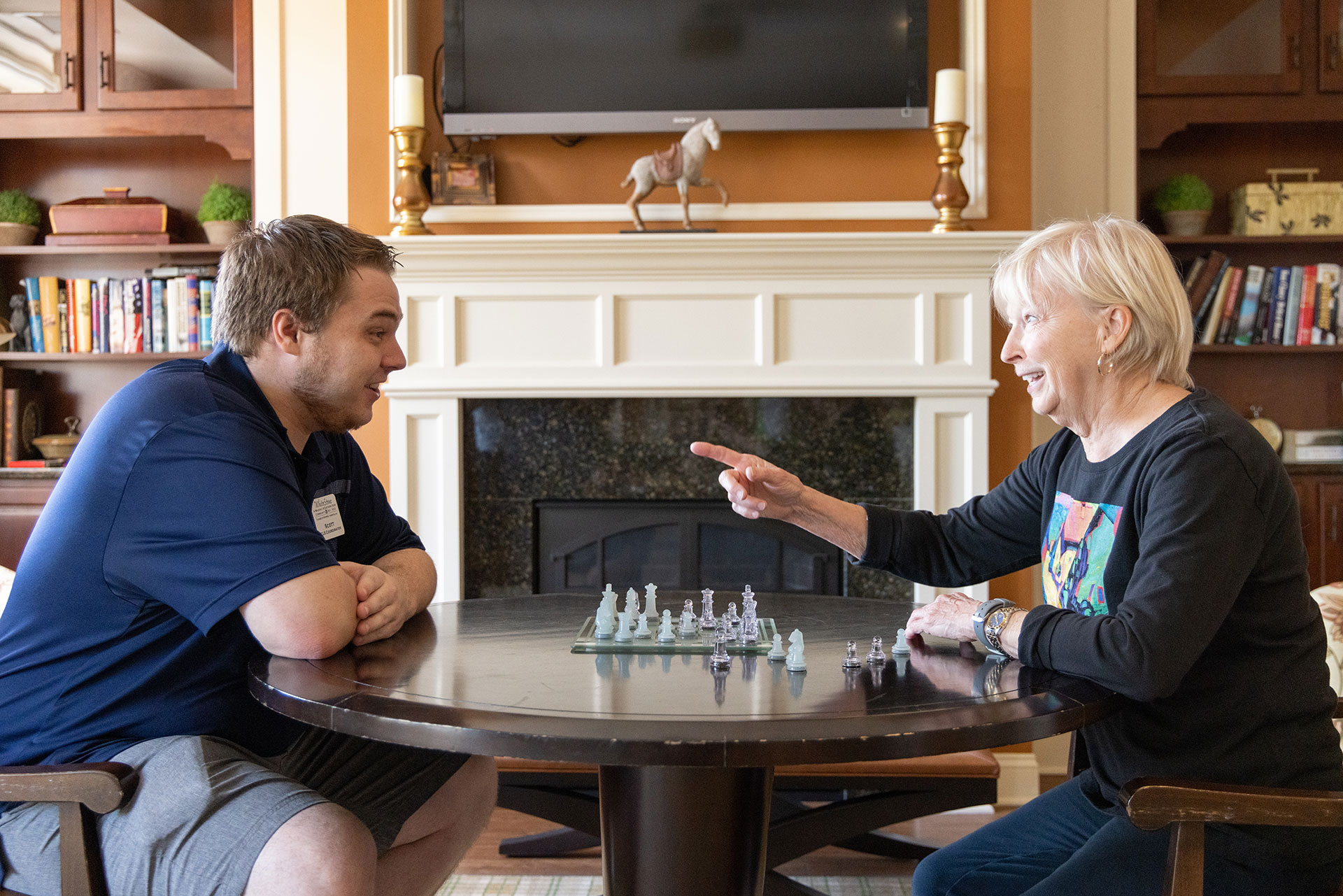 life enrichment coordinator, Scott Oliver, playing chess with a Whitestone resident