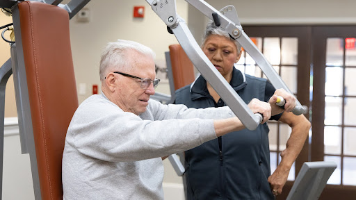 senior man with osteoporosis in the gym with his WhiteStone trainer