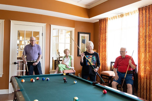 seniors enjoying the life plan community of Whitestone playing pool with friends