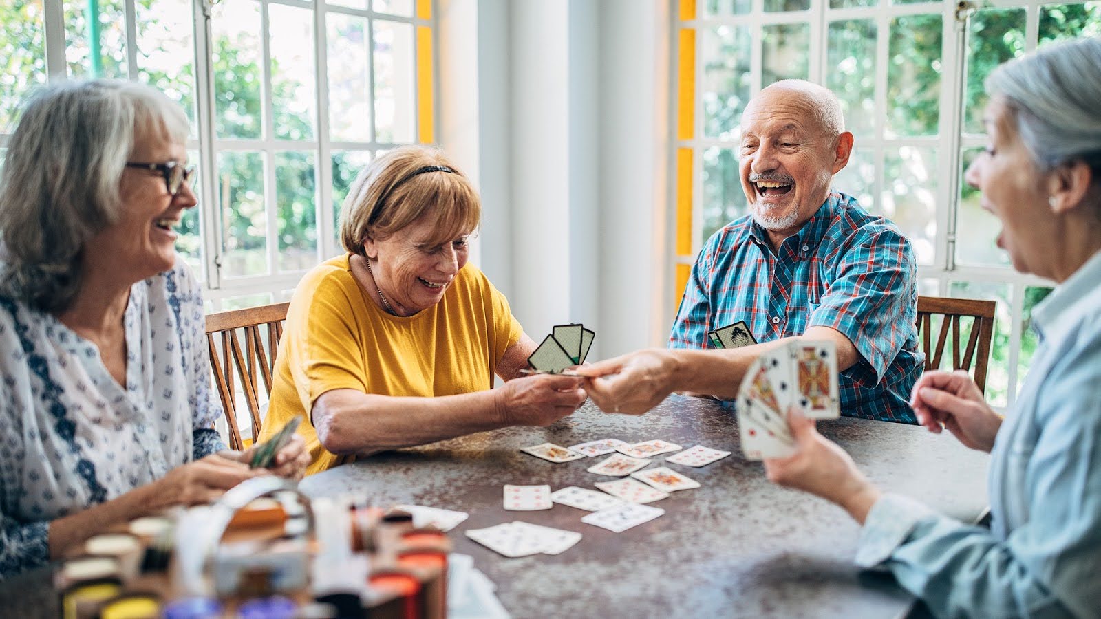 Group of senior friends playing cards