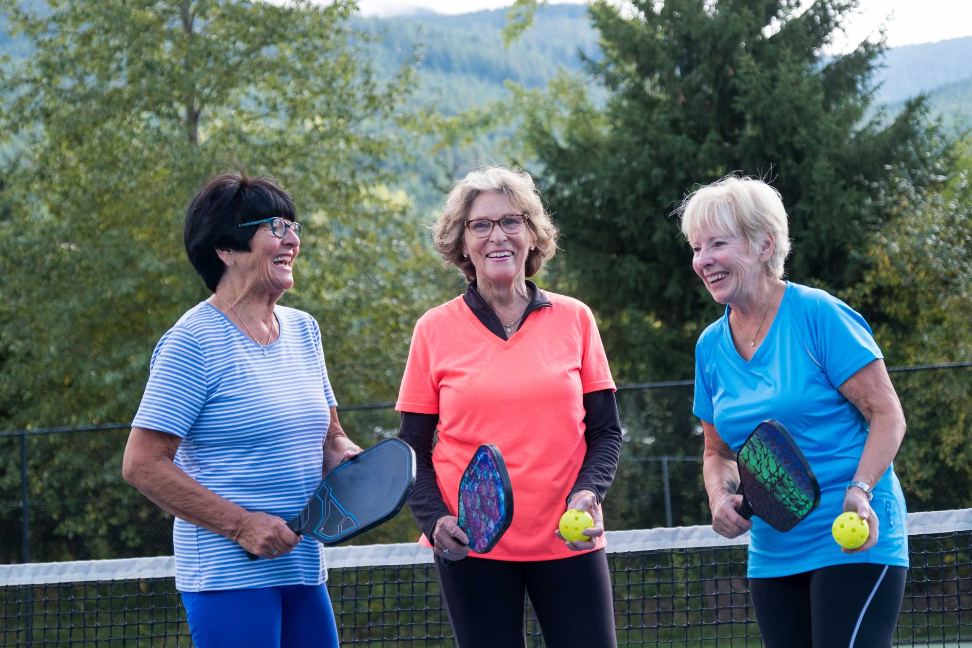 a group of senior women outside playing pickleball