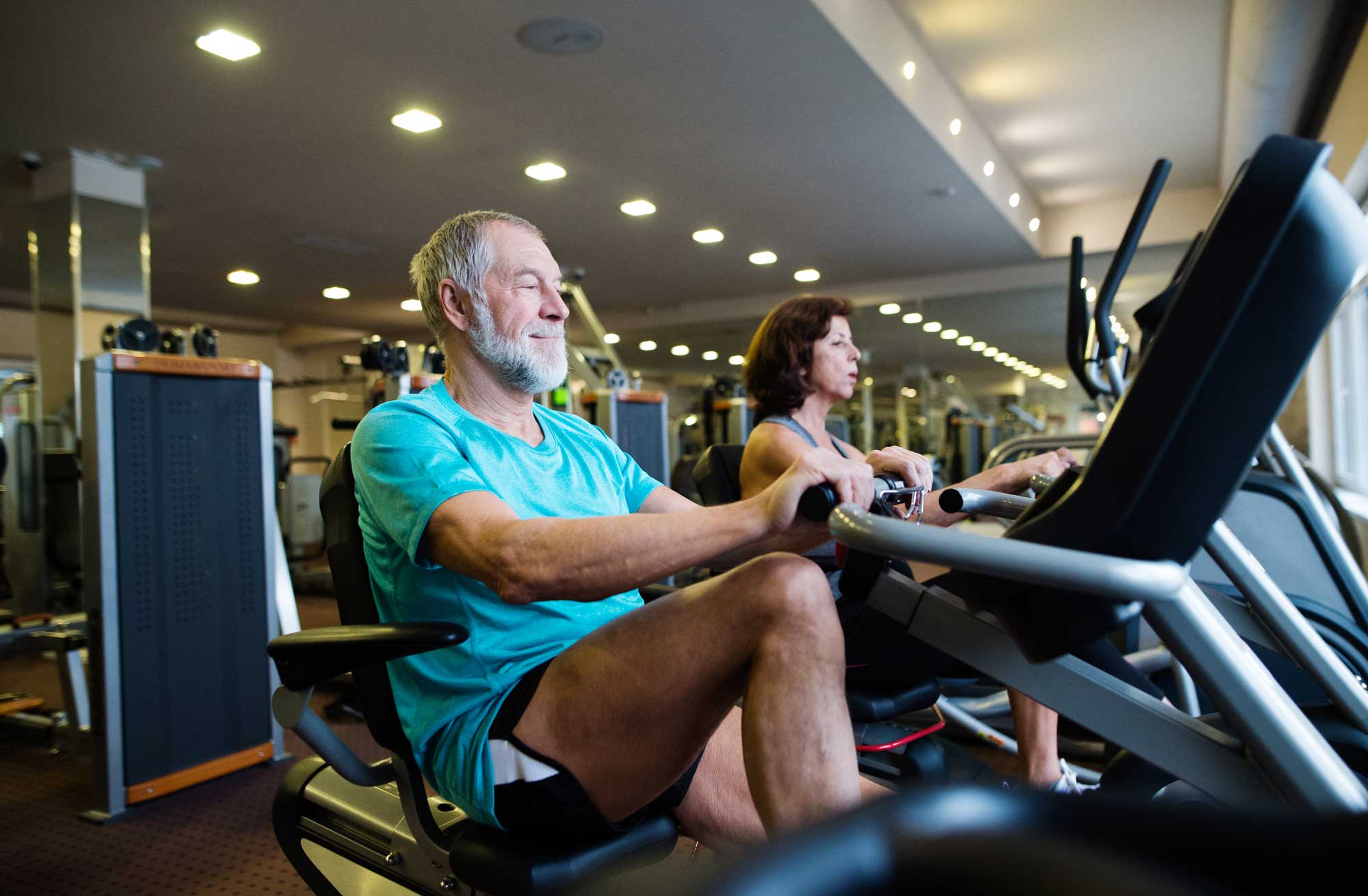 senior man using an exercise bike at the gym