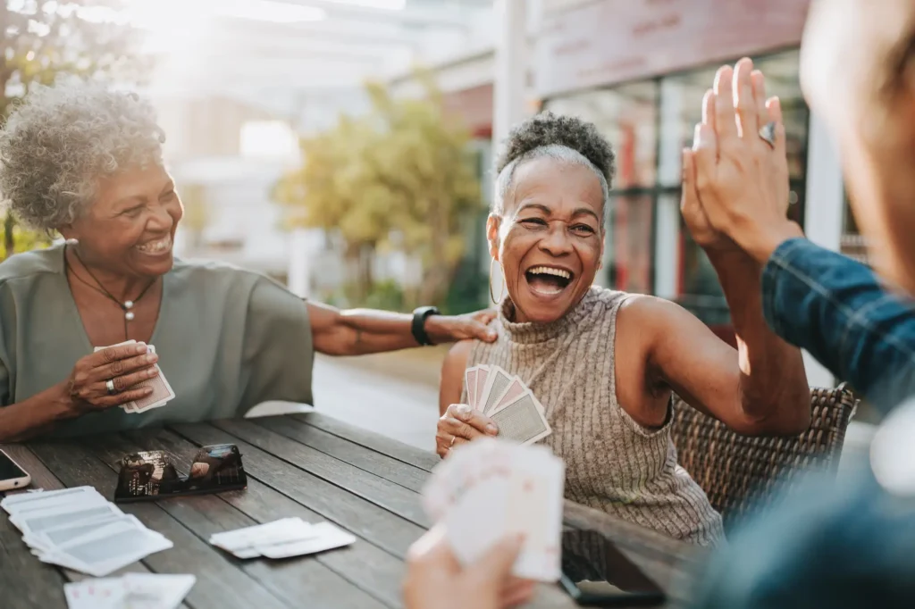 senior living residents playing cards outside