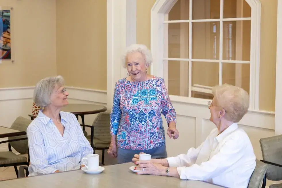 A group of senior women having coffee and talking about the best age to move to independent living at WhiteStone.