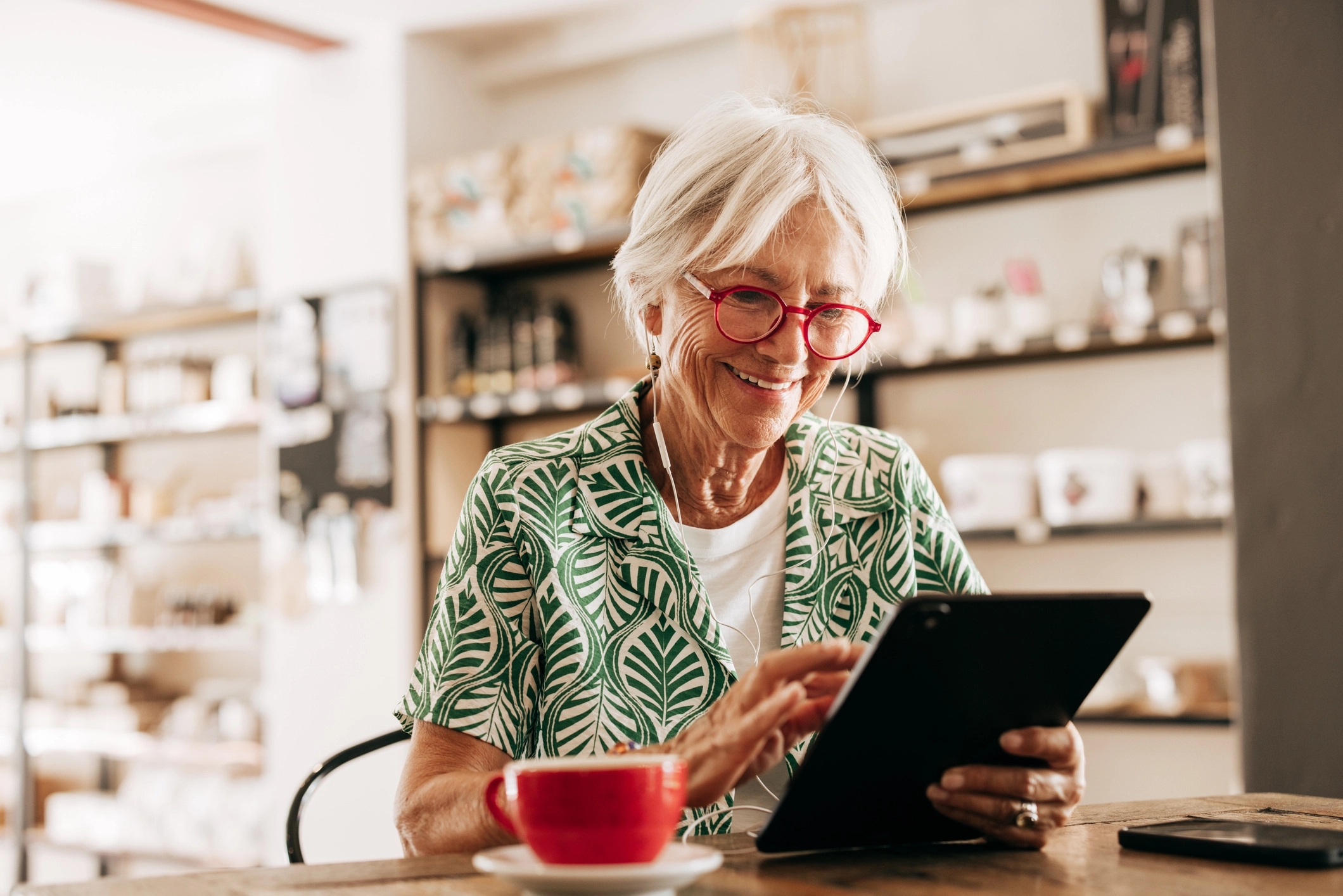 An elderly woman with tablet researching lifelong learning programs for seniors in her home at WhiteStone in Greensboro, SC.