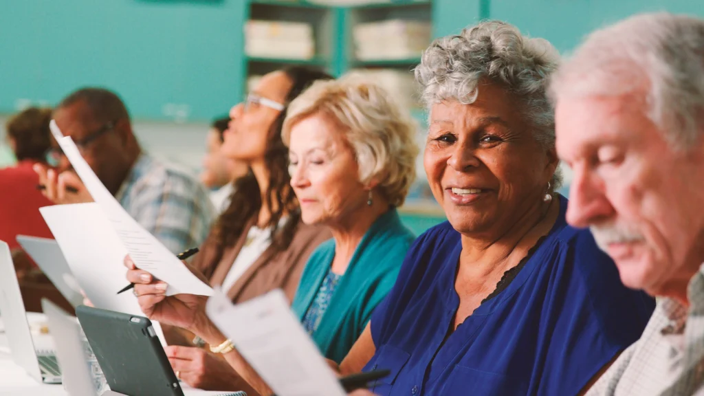 A group of elderly men and women taking an in-person class to explore lifelong learning for seniors at WhiteStone, a retirement home in Greensboro, SC.